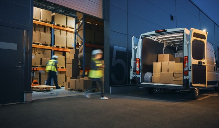 Outside of Logistics Distributions Warehouse Diverse Team of Workers Loading Delivery Truck with Cardboard Boxes. Online Orders, Purchases, E-Commerce Goods, Supply Chain. Blur Motion Shot.