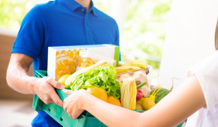 Grocery delivery guy handing goods to customer