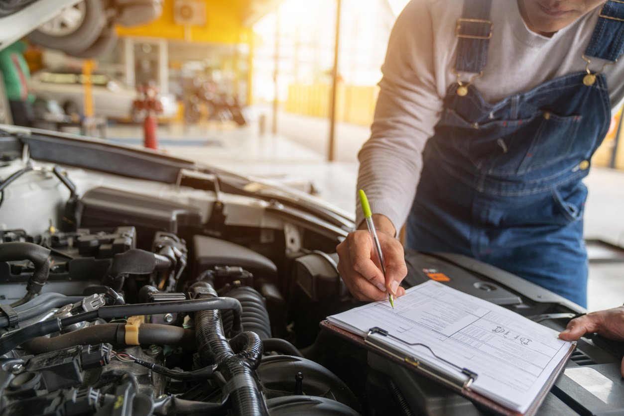 Man with a notepad while performing vehicle inspection