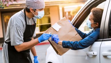 Caucasian mature woman picking her restaurant food from her car at a Curbside pickup
