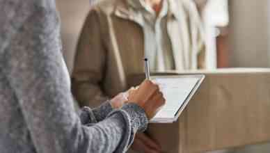 Closeup shot of a woman using a proof of delivery app to sign for her delivery from the courier