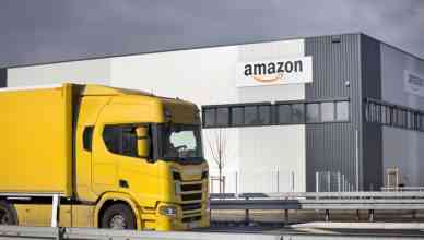 Facade of new logistics center of amazon as a part of Amazon supply chain in Raunheim-Moenchhof, Germany. Amazon (Amazon.com, Inc.) is an American electronic commerce and cloud computing company and the largest Internet retailer in the world as measured by revenue and market capitalization. In the foreground a passing freight truck