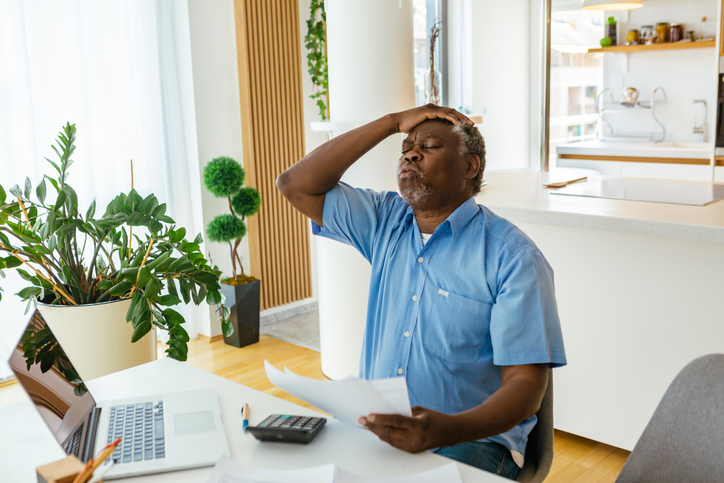 A nervous african-american shocked to see inaccurate invoice