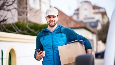 An independent courier guy getting his deliveries out of van. Food deliveries, groceries and supplies during COVID-19 isolation.