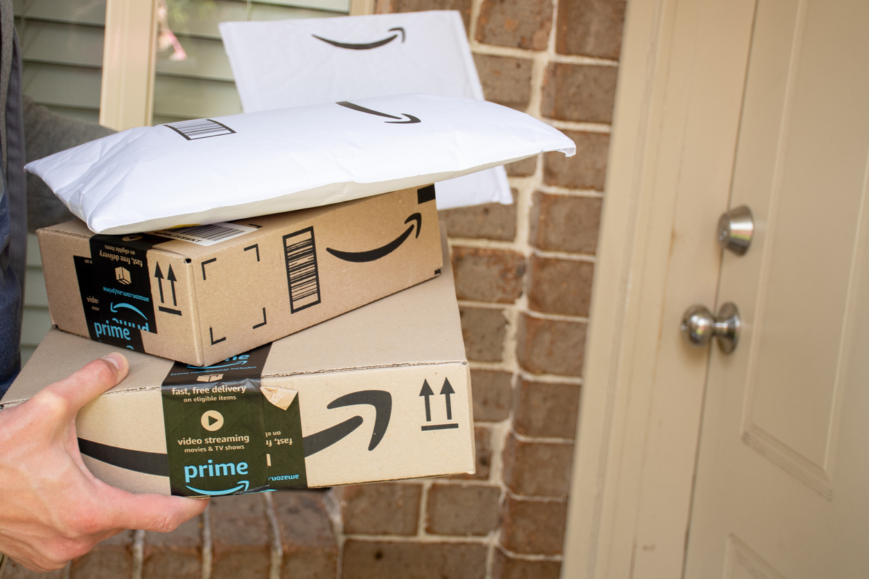 S Amazon prime boxes and envelopes delivered to a front door of residential building.